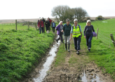 Photo of group walking around the base of the hill below St Catherine's Chapel – March 20, 2024