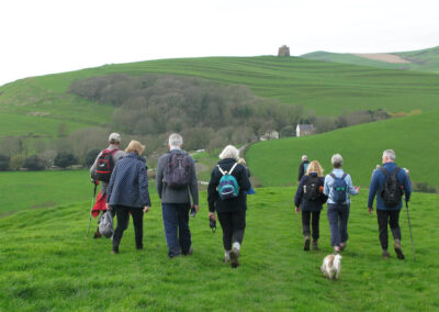 Photo of walkers with St Catherine's Chapel in the distance (1) – March 20, 2024