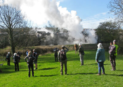 Photo of walkers watching a steam locomotive leaving Swanage – March 29, 2025