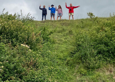 Photo of four walkers atop the huge mound that once formed part of a World War II rifle range in Martin Down National Nature Reserve – June 4, 2025