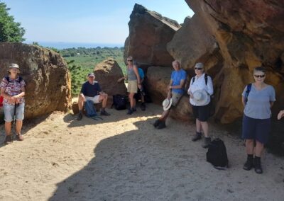 Photo of group enjoying the shade provided by Agglestone Rock on a sunny day – June 18, 2025