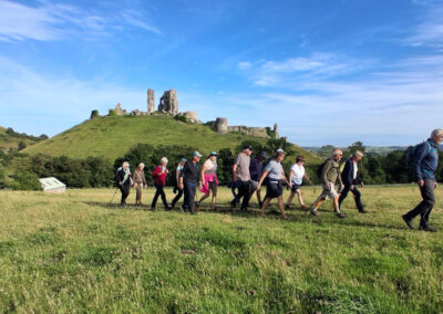 Photo of walkers with Corfe Castle in the background – June 26, 2025