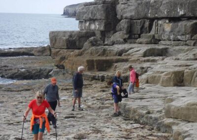 Photo of walkers on the rock ledges at Seacombe – October 1, 2025