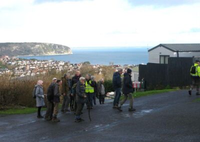 Photo of walkers passing through Swanage Bay View Holiday Park with Swanage and Ballard Down in the distance – December 3, 2025