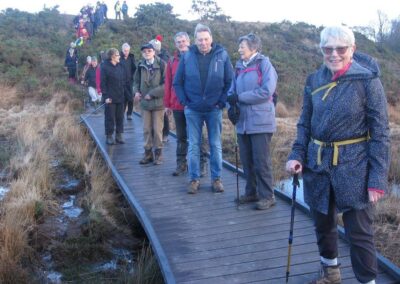 Photo of walkers on a boardwalk crossing boggy ground – December 10, 2025