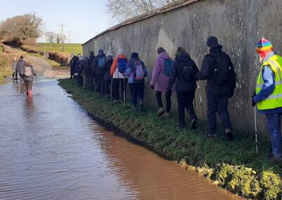 Photo of walkers tackling flood water on a road – February 14, 2026