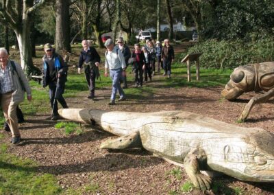 Photo of walkers passing carved wooden animals at Canford Cliffs – February 25, 2026