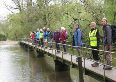 Photo of walkers crossing footbridge over River Frome at the ford in Moreton – April 15, 2026
