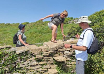 Photo 1 of walkers negotiating a tricky stone stile – May 23, 2026