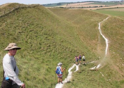 Photo of walkers on steep descent to middle ring at Maiden Castle – July 15, 2026