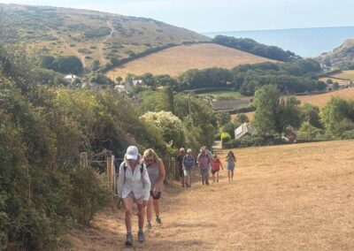 Photo of walkers on steep climb up West Down hill – August 8, 2026