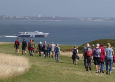 Photo of walkers on Old Nick's Ground with ferry to Jersey in the distance – September 19, 2026